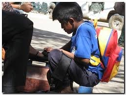 niño trabajando en embolar zapatos